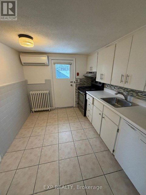A kitchen with white cabinets and a tiled floor.