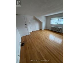 A room with wooden flooring and a window with blinds.