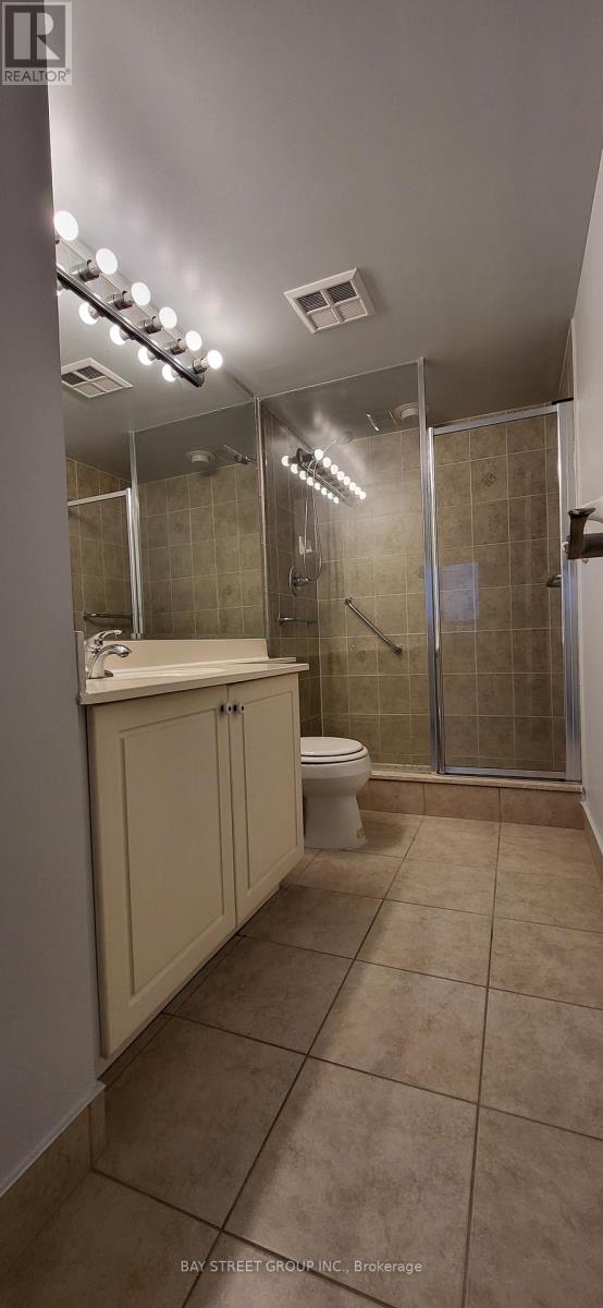 A bathroom with a toilet, sink, and shower.