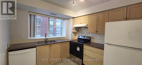 A kitchen with wooden cabinets and a white refrigerator.