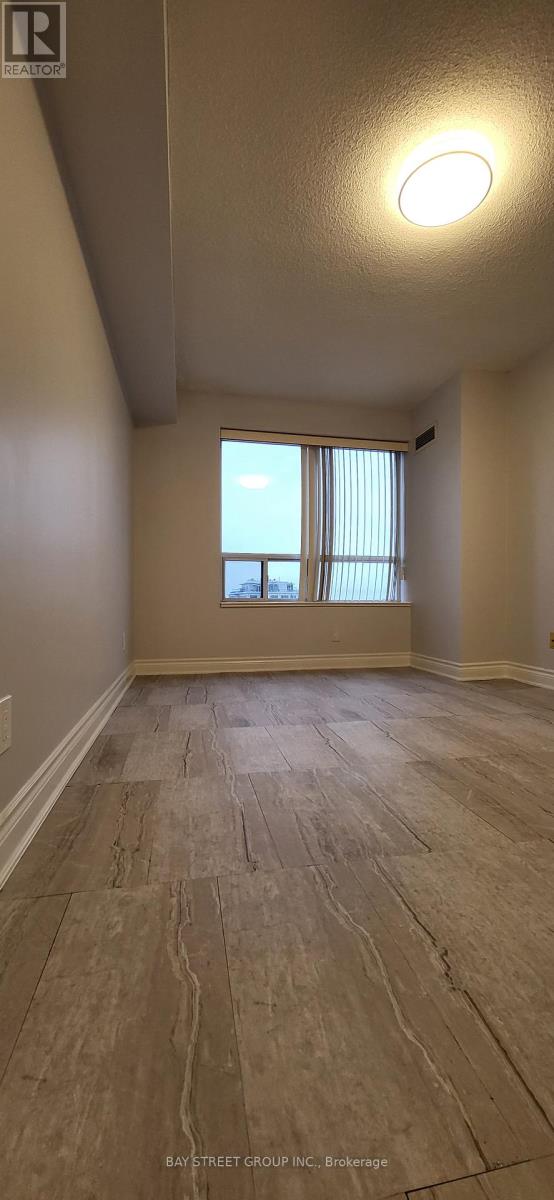 A room with a window and a wooden floor.