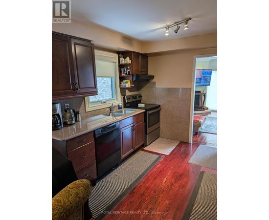A kitchen with wooden cabinets and a red floor.