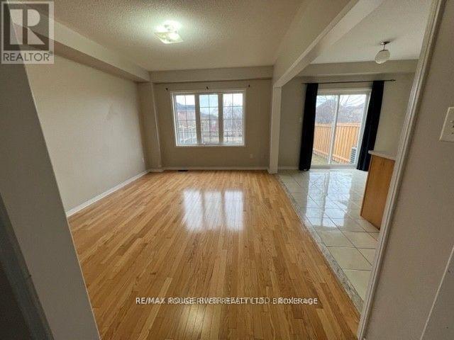 A spacious room with wooden flooring and a large window.
