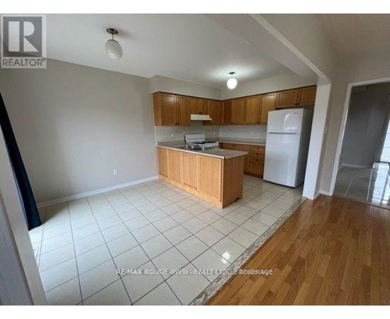 A kitchen with wooden cabinets and a white refrigerator.