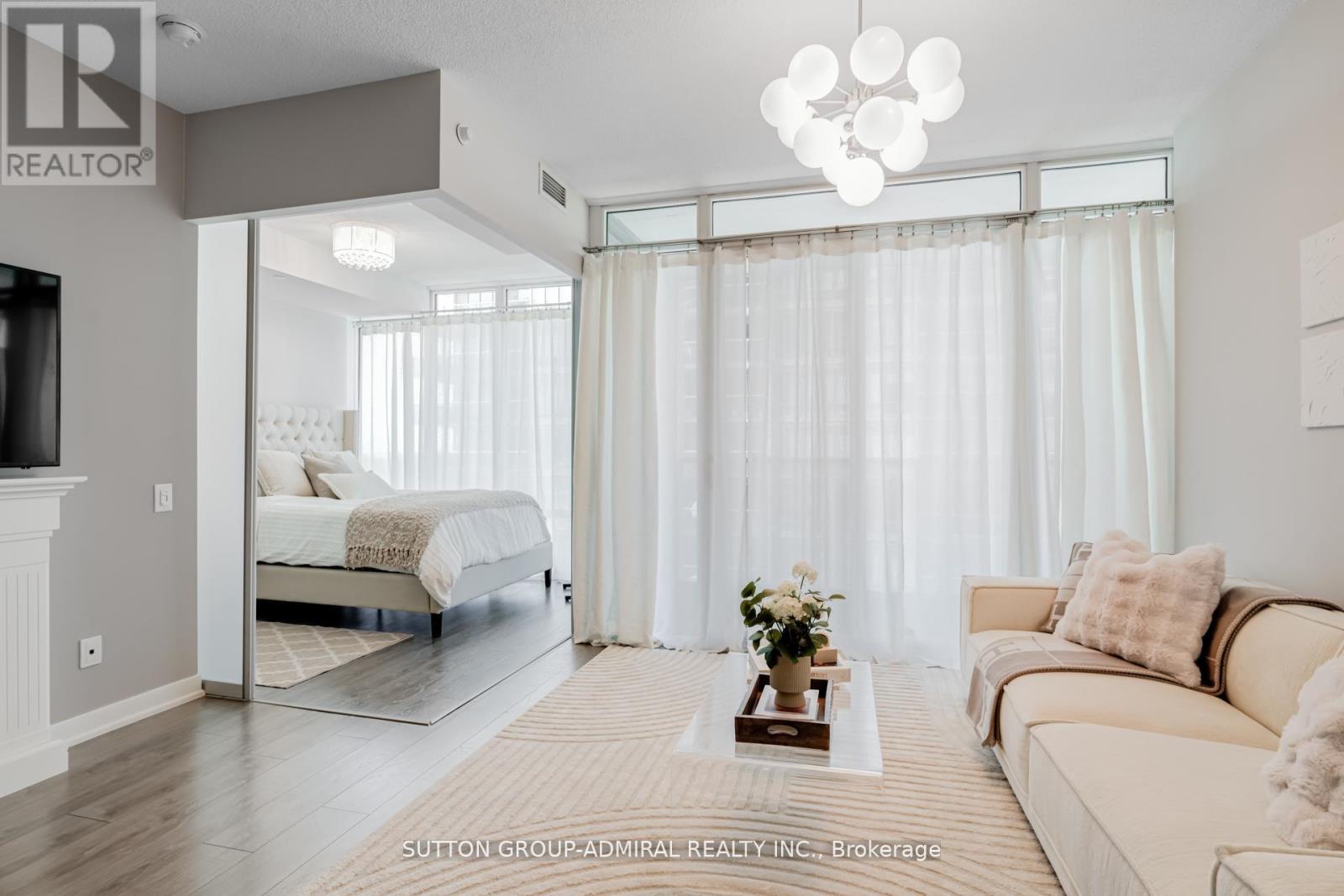 A well-lit bedroom with a large bed and a couch.