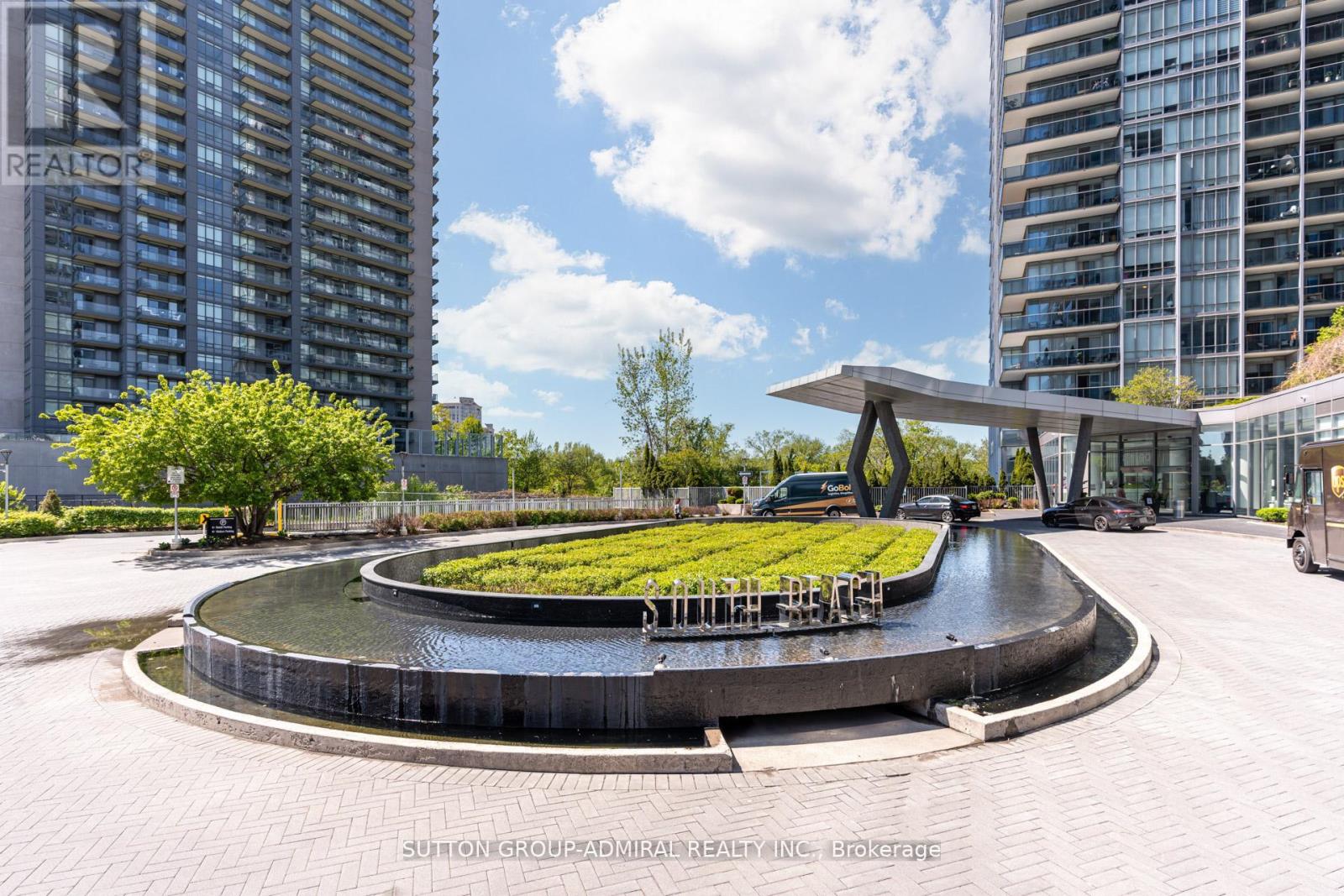 A modern courtyard with a water feature and a green space in the middle.