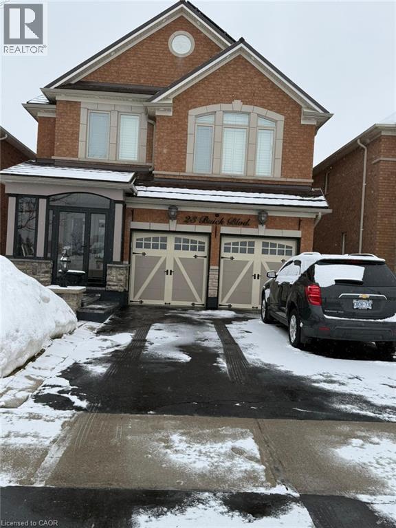 A black SUV is parked in front of a brick house.