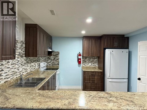 A kitchen with brown cabinets and a white fridge.