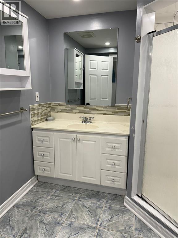 A bathroom with a sink, mirror, and cabinets.