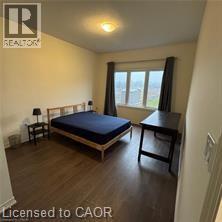 A bedroom with a bed, a chair, and a table.