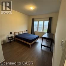 A bedroom with a bed, a chair, and a table.