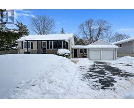 A house with a snow-covered driveway in front.