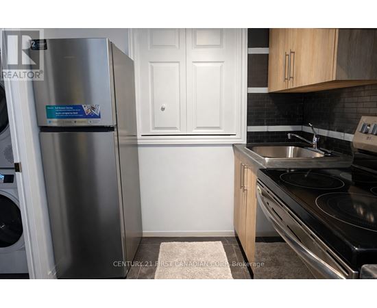 A kitchen with a stainless steel refrigerator and a stove top oven.