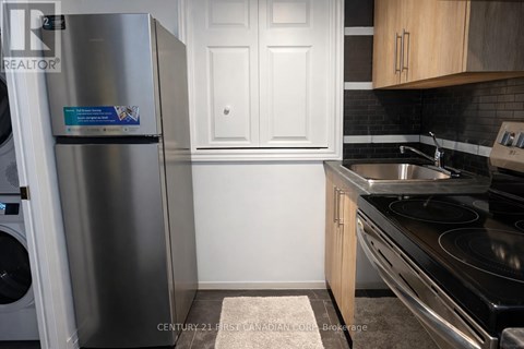 A kitchen with a stainless steel refrigerator and a stove top oven.