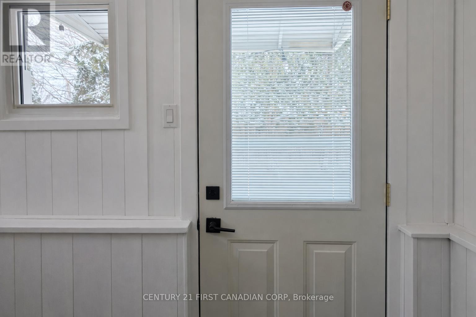 A white door with a window above it in a room.