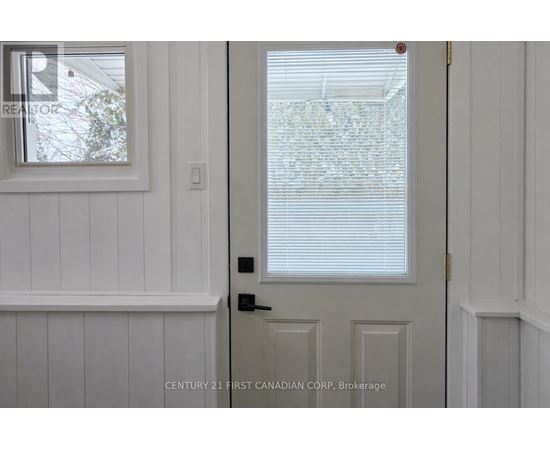 A white door with a window above it in a room.
