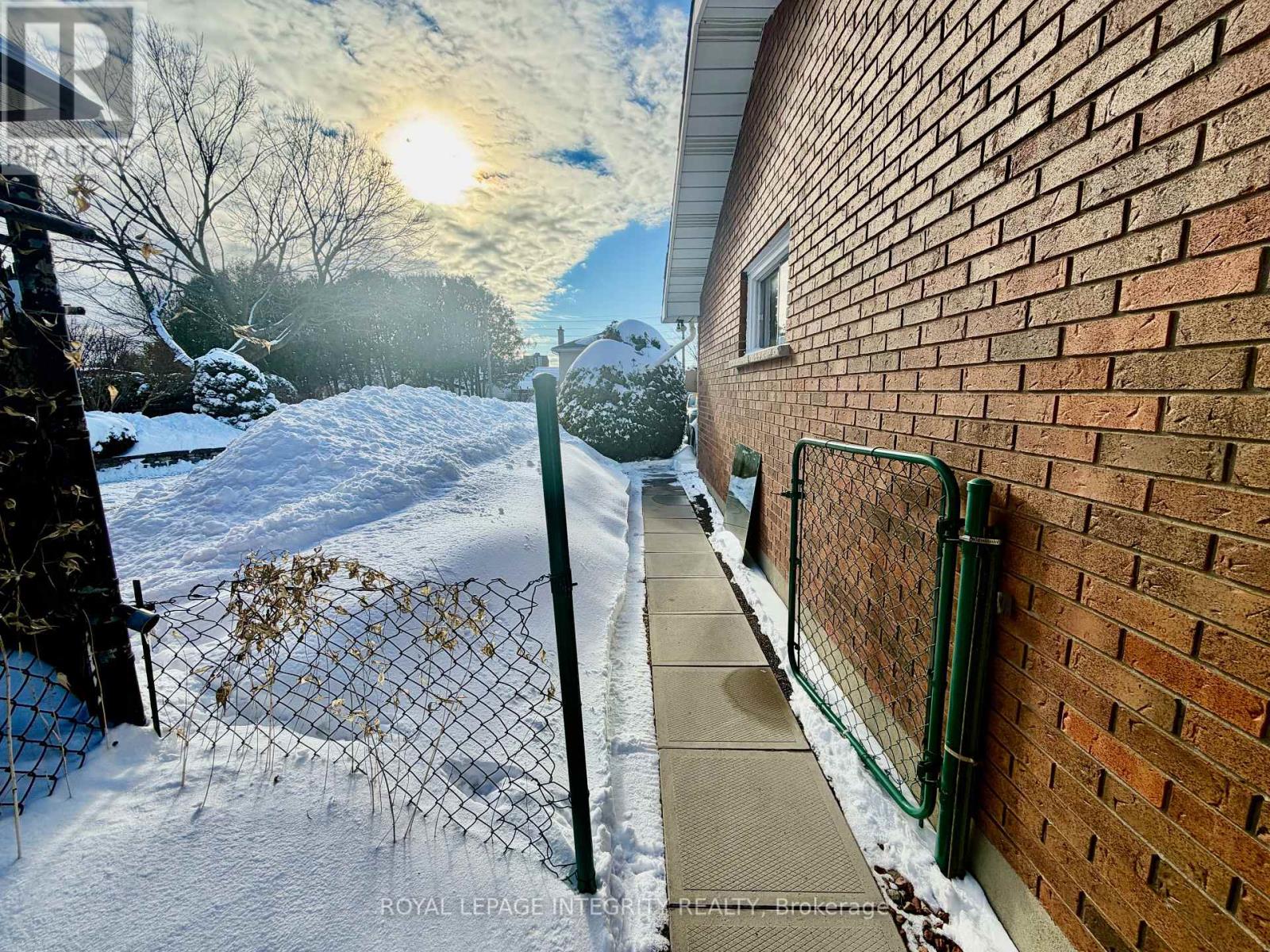 A snowy scene with a sun shining through the clouds.