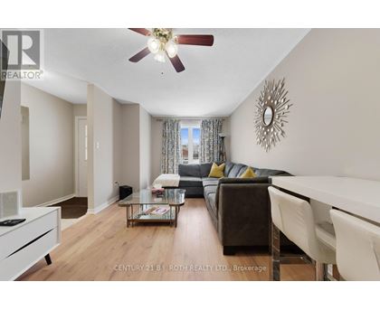 A living room with a brown couch and a ceiling fan.