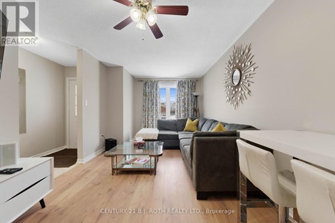 A living room with a brown couch and a ceiling fan.