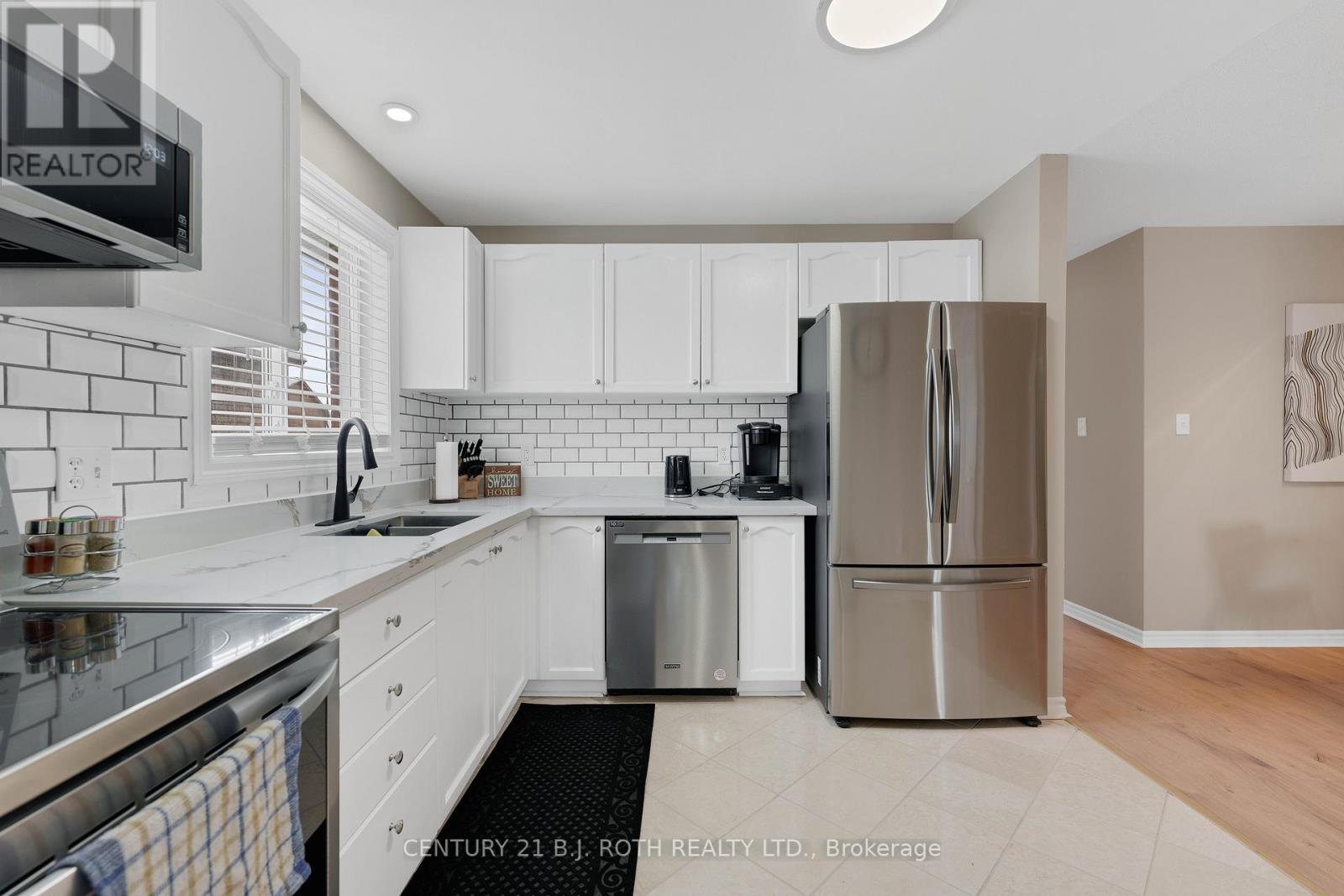 A modern kitchen with white cabinets and stainless steel appliances.