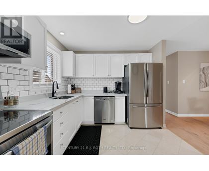 A modern kitchen with white cabinets and stainless steel appliances.
