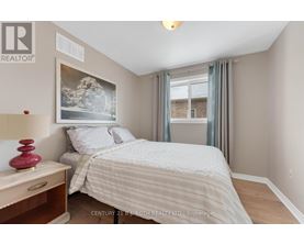 A bedroom with a bed, nightstand, and a painting on the wall.