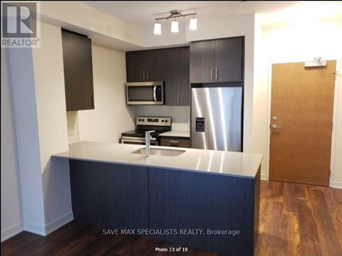 A kitchen with a stainless steel refrigerator and microwave.