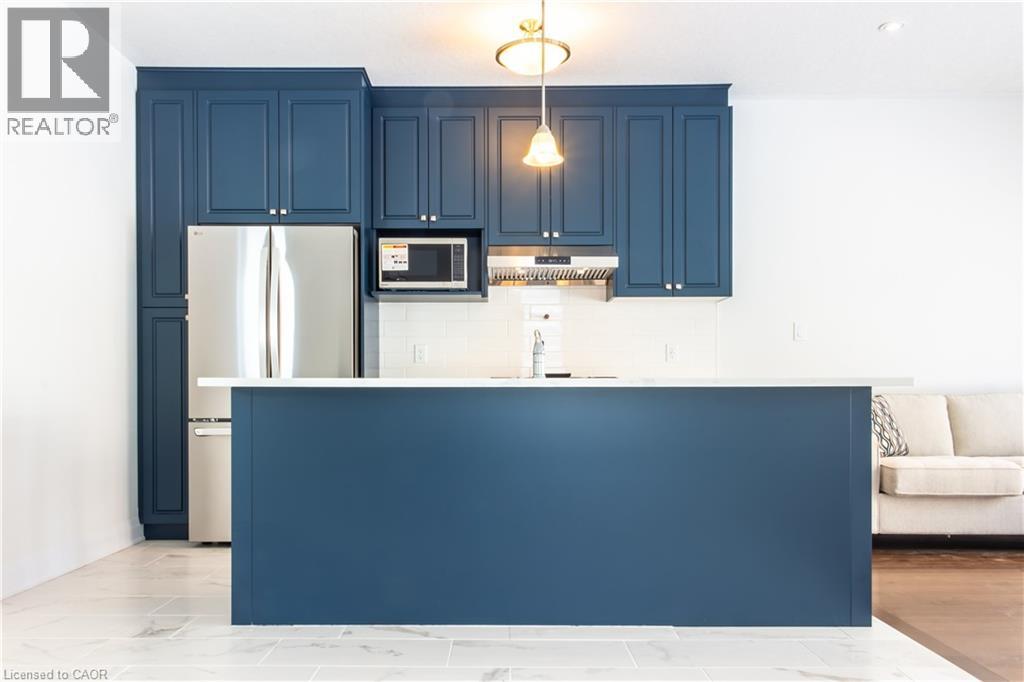 A kitchen with dark blue cabinets and a white counter.