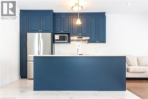 A kitchen with dark blue cabinets and a white counter.