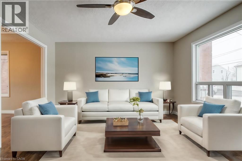 A living room with a white couch, a coffee table, and a painting on the wall.