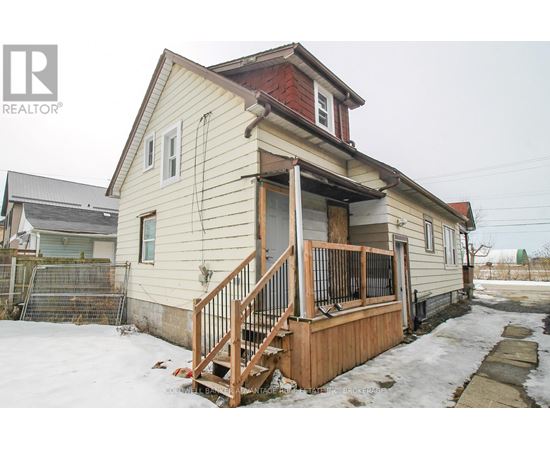 A house with a red roof and a wooden deck in the snow.