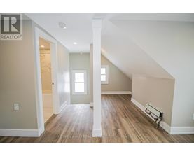 A spacious room with wooden floors and white walls.