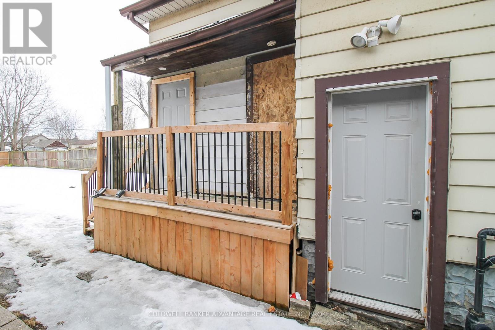 A house with a boarded up window and a wooden fence.