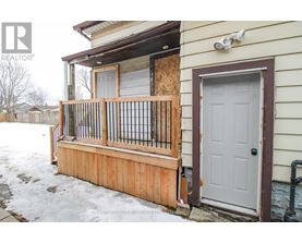 A house with a boarded up window and a wooden fence.