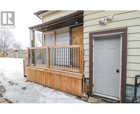 A house with a boarded up window and a wooden fence.