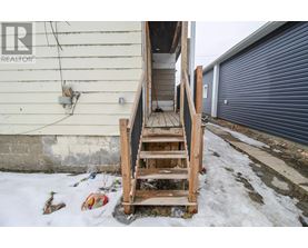 A wooden staircase leading to a garage door.