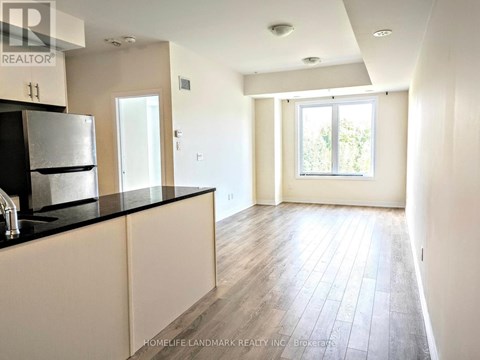 A kitchen with white cabinets and a black countertop.