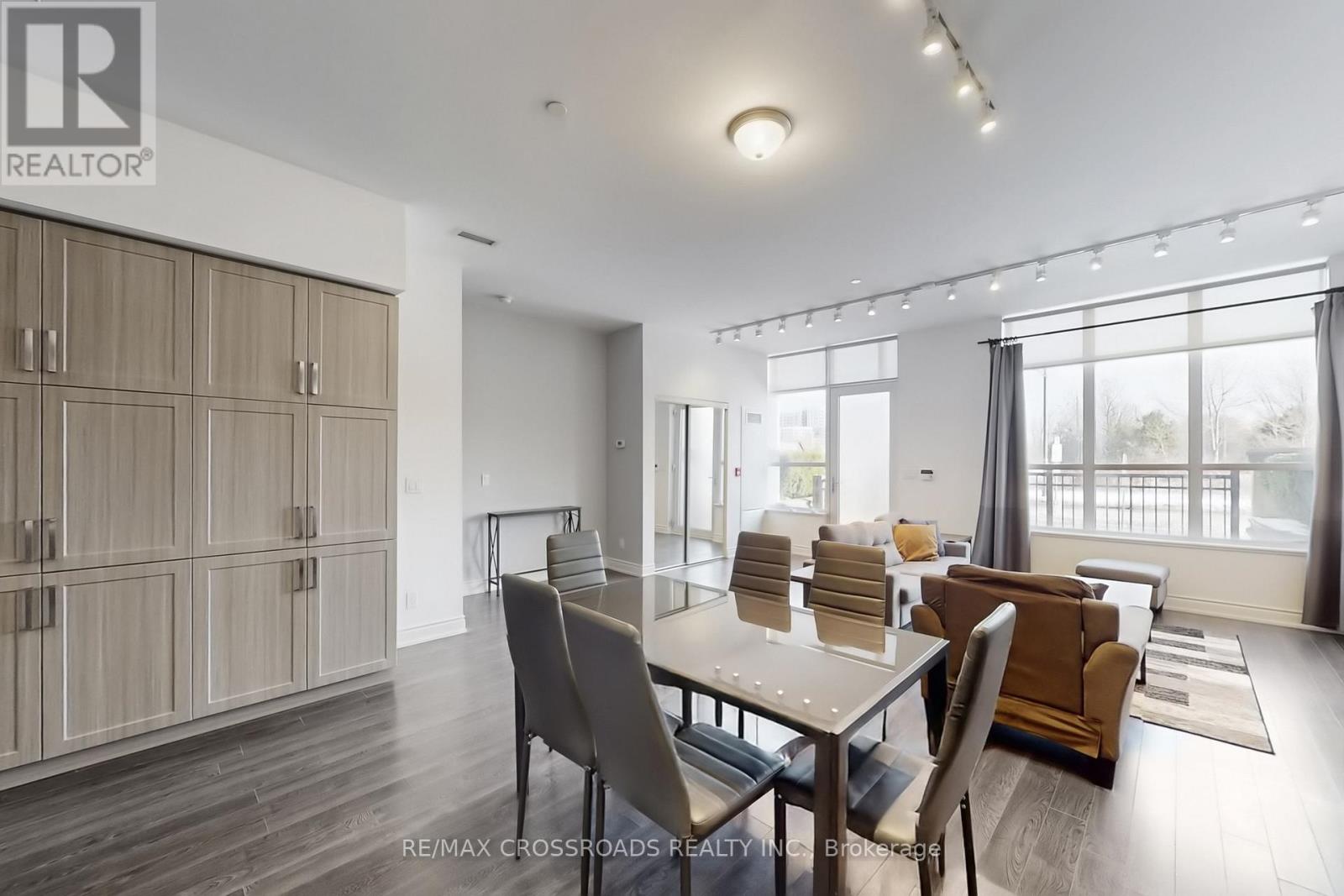 A dining room with a table set for four and chairs around it.