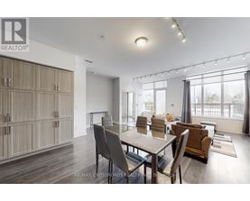 A dining room with a table set for four and chairs around it.