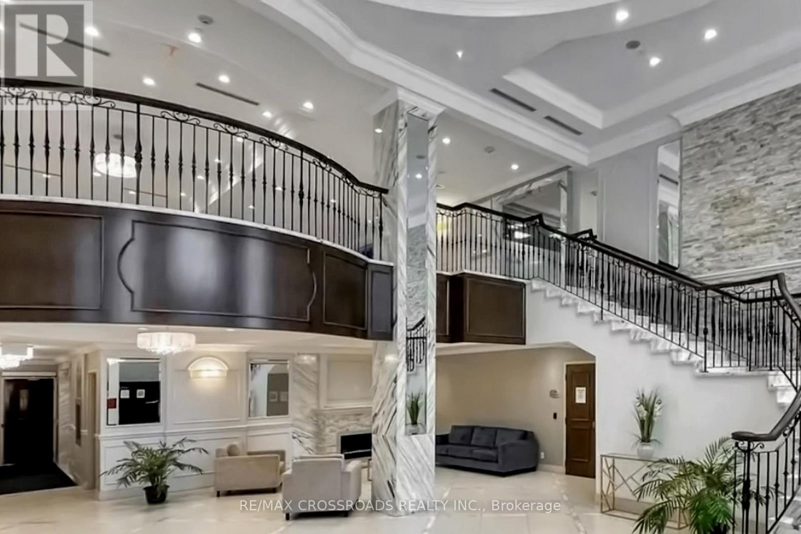 A spacious interior of a building with a staircase and a reception area.
