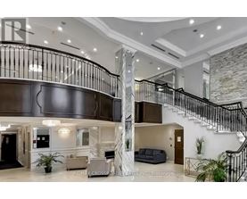 A spacious interior of a building with a staircase and a reception area.