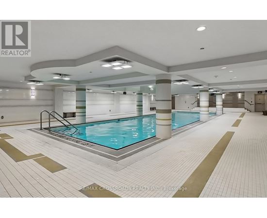 A large indoor swimming pool with a tiled floor and walls.