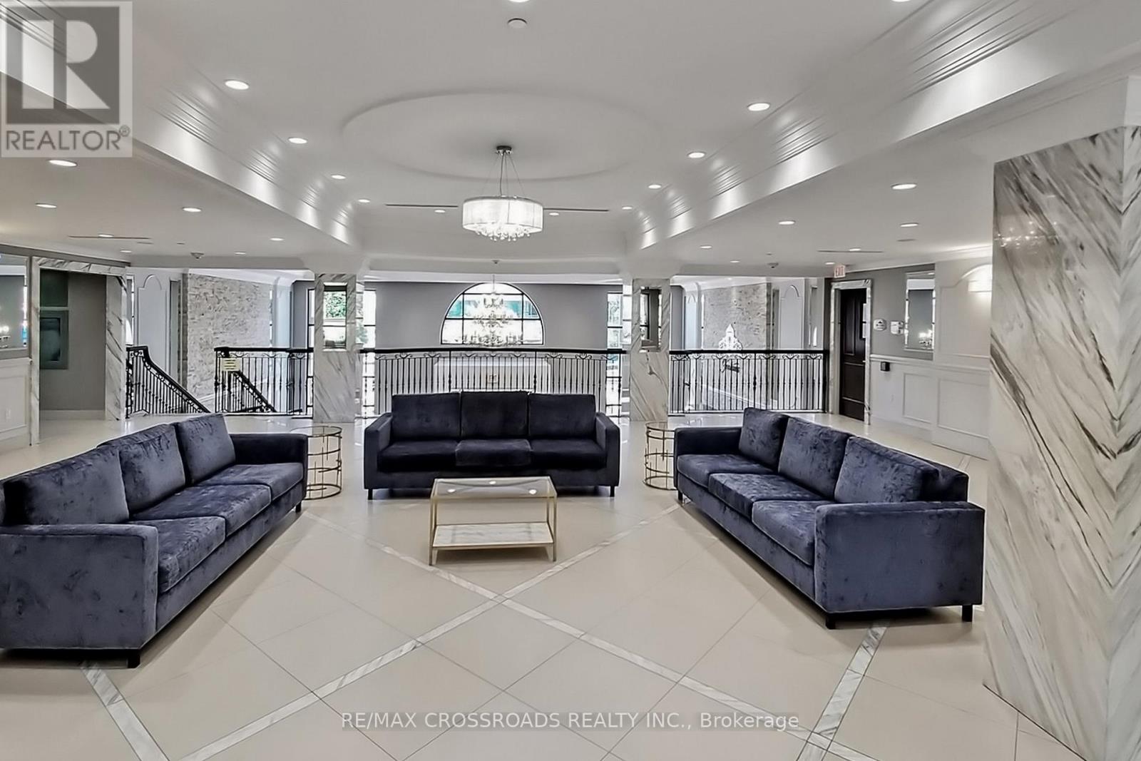 A spacious living room with a black sofa and a coffee table.