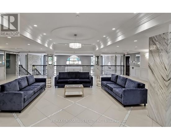 A spacious living room with a black sofa and a coffee table.