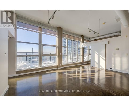 A spacious room with large windows and a view of the outside.