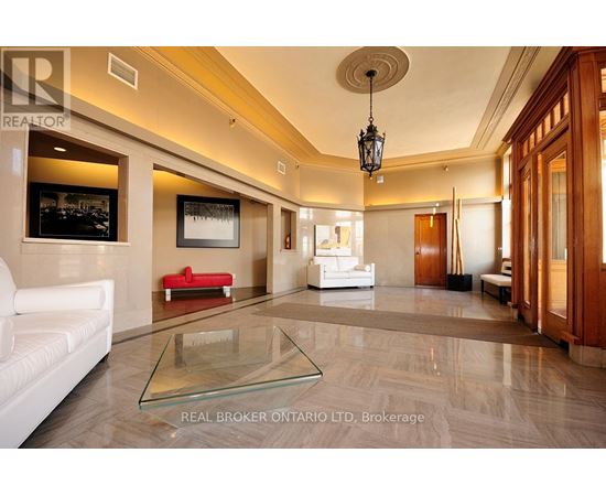 A spacious living room with a glass coffee table and a red sofa.