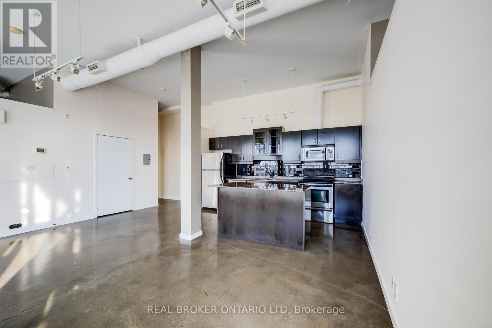 A spacious kitchen with stainless steel appliances and a large island.