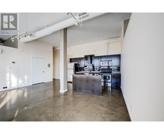 A spacious kitchen with stainless steel appliances and a large island.