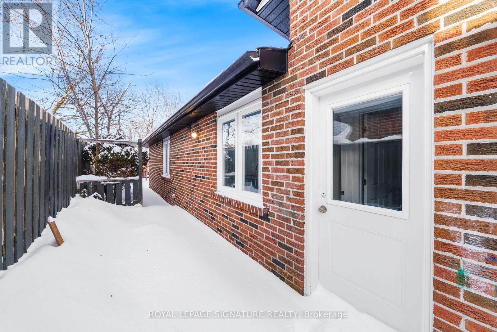 A white door is on the side of a brick building.