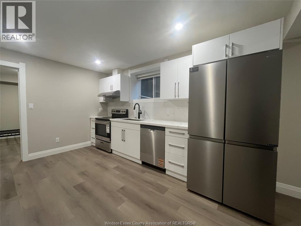 A kitchen with a refrigerator, stove, and sink.